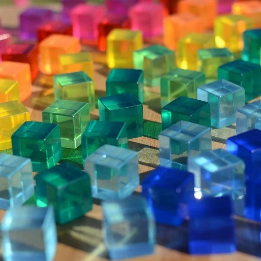 Close-up of translucent Bauspiel Lucent Cubes in green, blue and orange catching the light