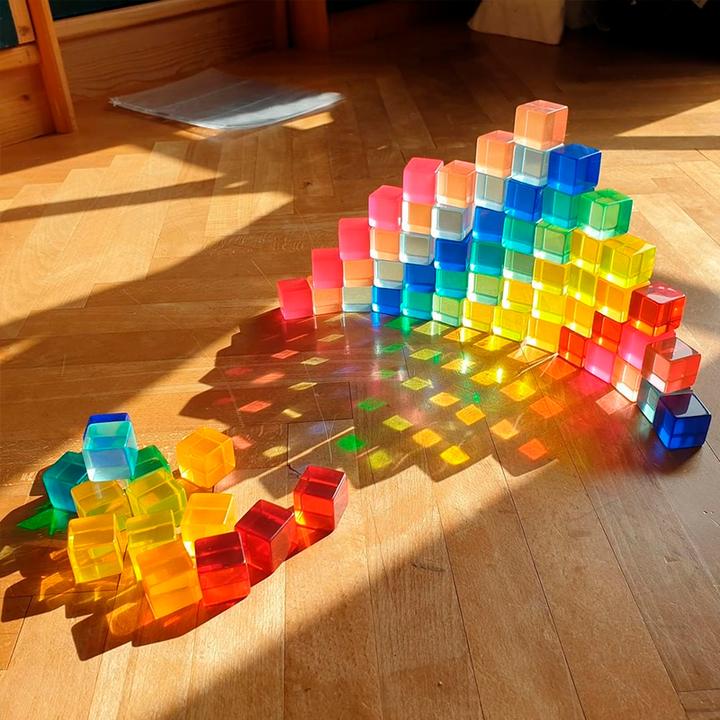 Bauspiel Lucent Cubes built into a glowing rainbow arch on a sunny wooden floor