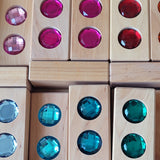 Close-up of Bauspiel Color Track blocks with large faceted gems in pink, teal and blue · view 5