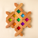 Bauspiel X-Blocks built into a flat pattern framing colored lucent cubes · view 1