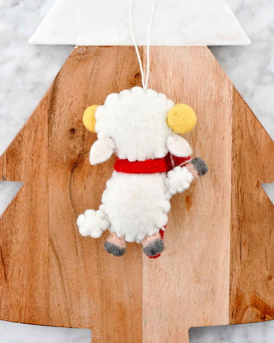 Back of the felt lamb ornament, showing its curly white wool coat and red scarf