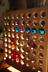 Colored Bauspiel lucent cylinders set in the holes of the wooden game board · view 6