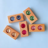 Five Bauspiel Color Track blocks with matching pairs of faceted gems in purple, green, red and gold · view 4