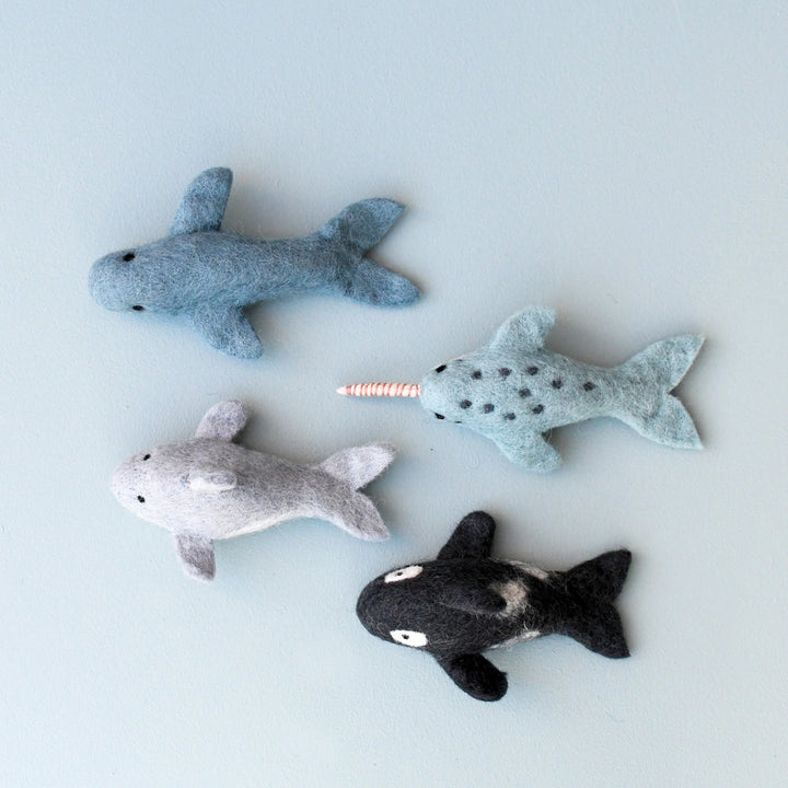 The four felt marine mammals laid out from above: whale, narwhal, dolphin and orca