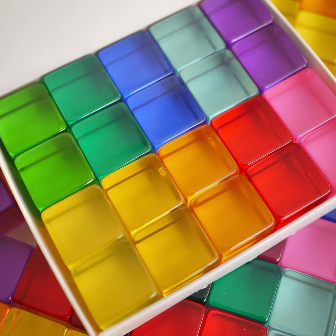 Close-up of 20 Bauspiel Lucent Cubes in bright colors in their box
